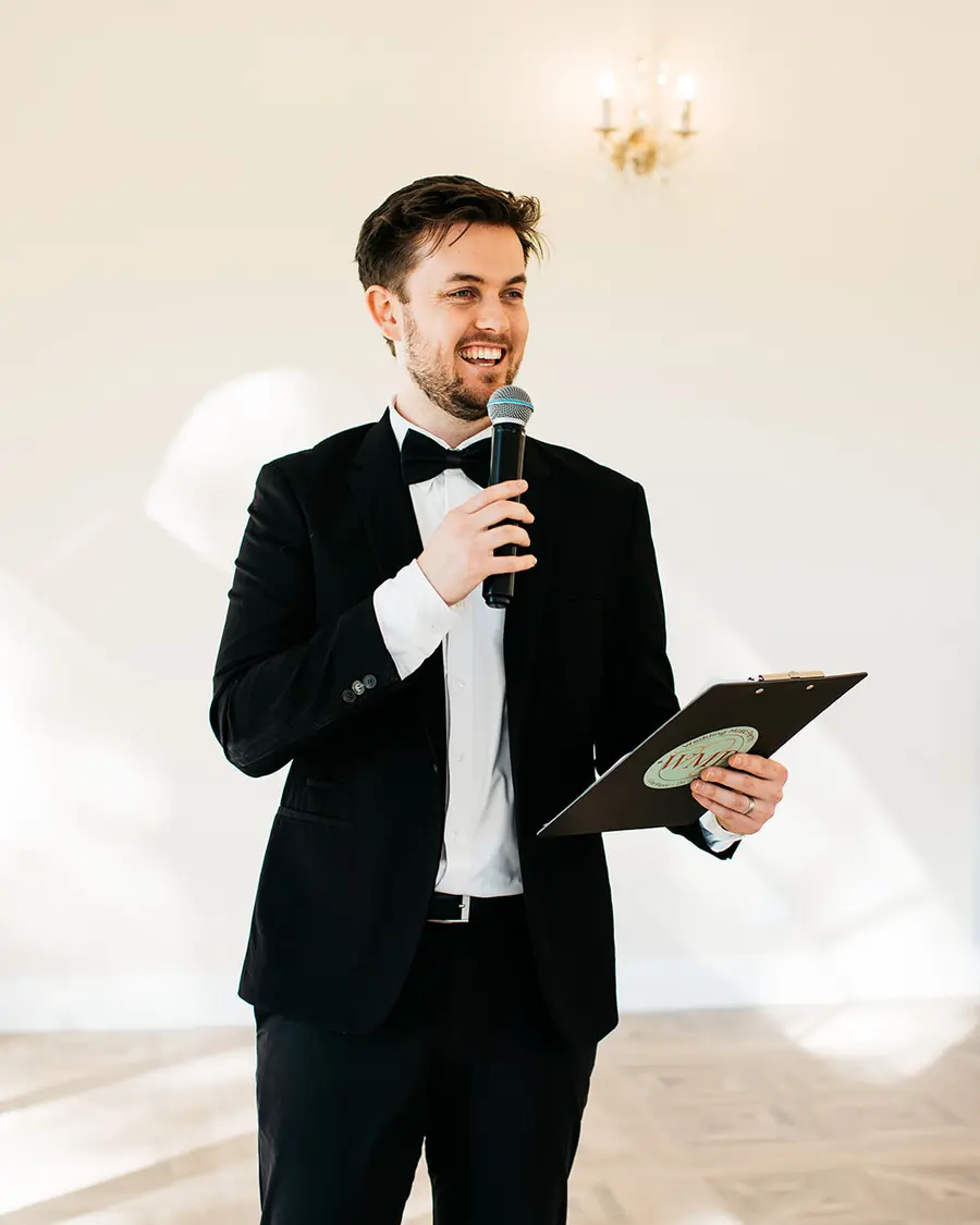 Mitchell Martin MCing a Perth wedding reception, microphone and runsheet in hand