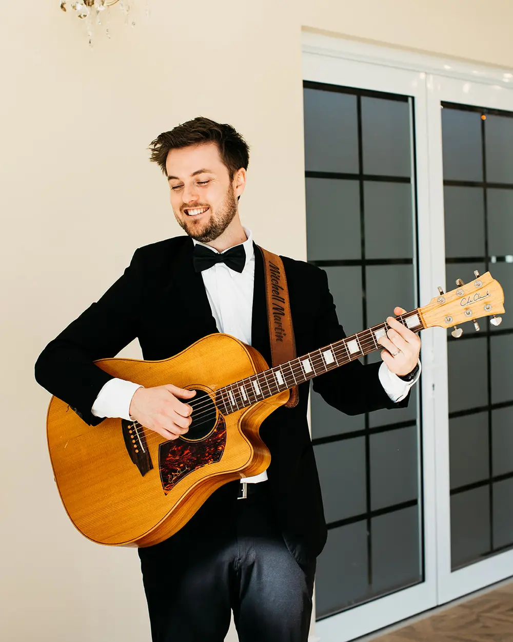 Mitchell performing live acoustic guitar at a wedding